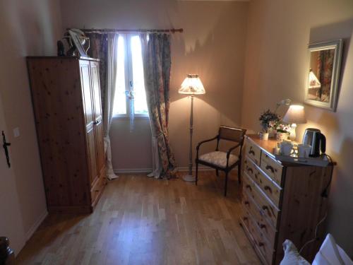 a bedroom with a dresser and a lamp and a window at Villa Magnolia in Seillans