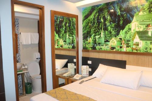 a bedroom with a bed with a painting on the wall at Eurotel Boracay in Boracay