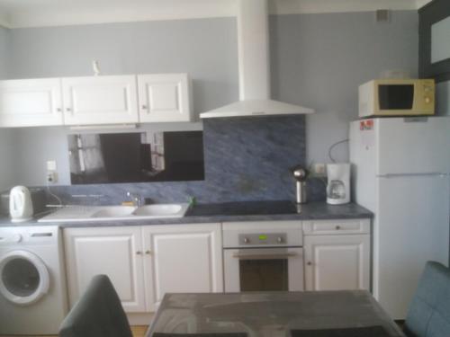 a kitchen with white cabinets and a white refrigerator at Villa Rue Gainekoa in Cambo-les-Bains