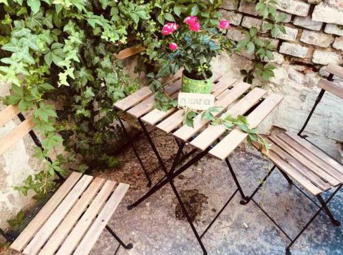 a wooden bench with a pot of flowers on it at Second home in heart of Bratislava in Bratislava
