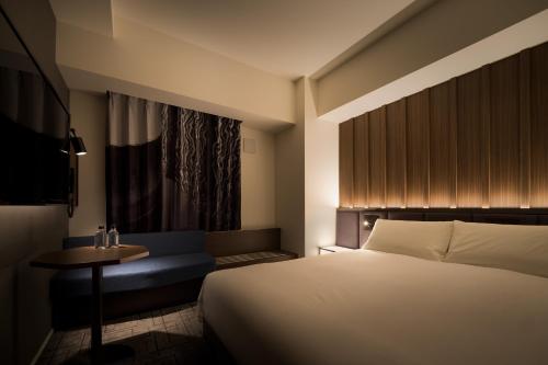 1 dormitorio con 1 cama, 1 mesa y 1 silla en Bespoke Hotel Shinsaibashi en Osaka