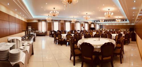 a banquet hall with tables and chairs and chandeliers at Dormitory Hualing Tbilisi in Tbilisi City