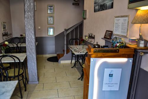 Un restaurante con mesas y sillas y un refrigerador. en Hotel des Remparts, en Villeneuve-sur-Lot