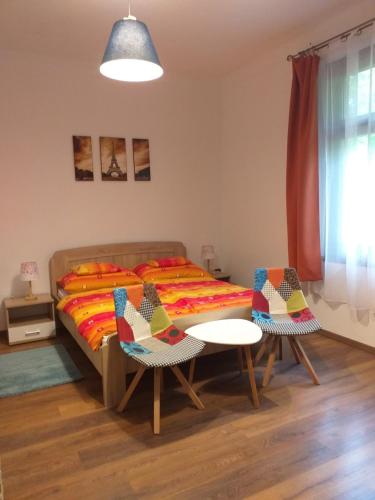 a bedroom with a bed and two chairs and a table at Balatonszemesi Nyaralóház in Balatonszemes