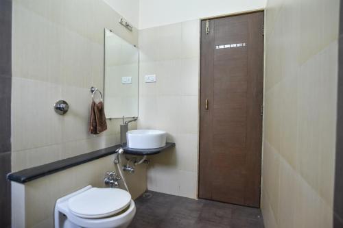 a bathroom with a toilet and a sink at Red Stone Villa Mahableshwar in Mahabaleshwar