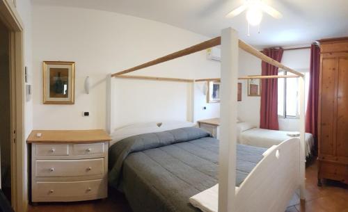 1 dormitorio con cama con dosel, mesita de noche y cama sidx sidx sidx sidx en B&B Casa Derosas en Golfo Aranci