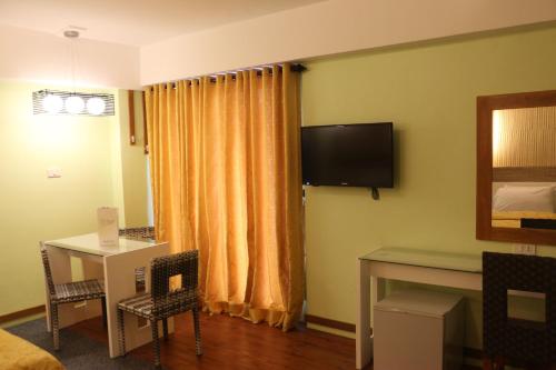 a hotel room with a bed and a desk and a television at Eurotel Boracay in Boracay