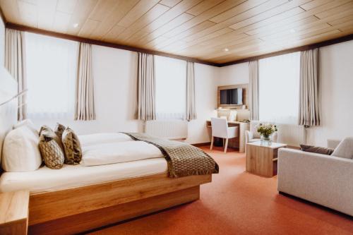 ein Schlafzimmer mit einem großen Bett in einem Zimmer mit Fenstern in der Unterkunft Hotel Frauensteiner Hof in Frauenstein