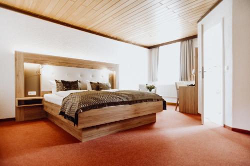 a bedroom with a large bed and a large window at Hotel Frauensteiner Hof in Frauenstein