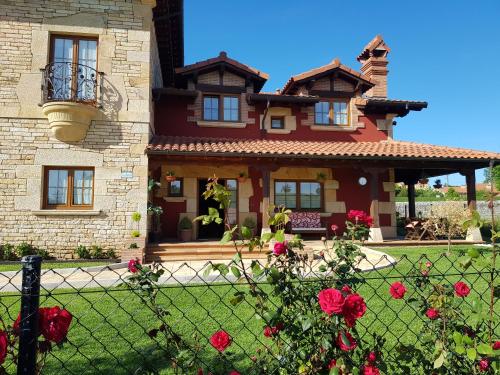 a house with red roses in front of it at Posada La Fabula in Santillana del Mar