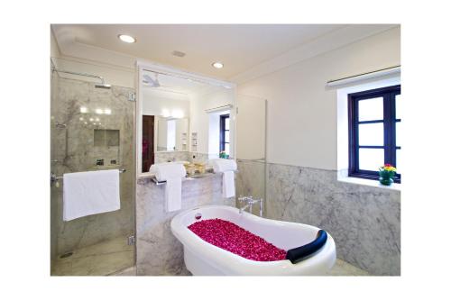 a bathroom with a bath tub with a shower at Sawai Madhopur Lodge - IHCL SeleQtions in Sawāi Mādhopur