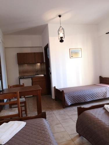 a room with two beds and a table and a kitchen at Katerina Apartments in Stalís