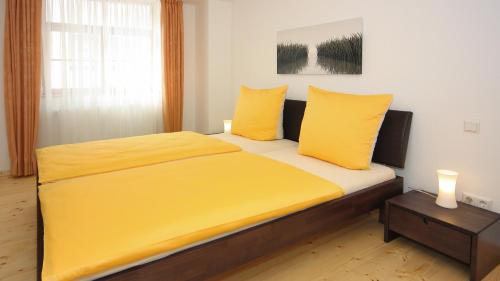 ein Schlafzimmer mit einem Bett mit gelber Bettwäsche und einem Tisch in der Unterkunft Ferienwohnung Braun in Meersburg