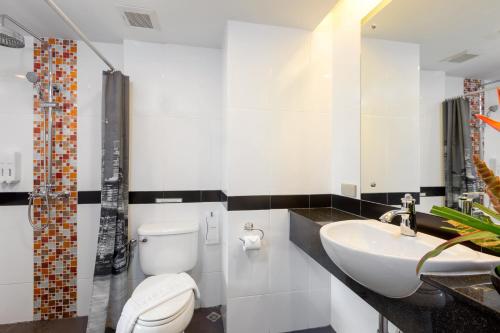 a bathroom with a white toilet and a sink at Lub Sbuy House Hotel - SHA in Phuket Town