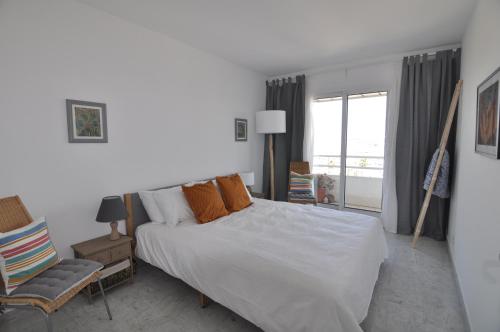 une chambre avec un grand lit blanc et une fenêtre dans l'établissement Stunning 2-bedroom apartment & panoramic sea view -StayInAntibes- 54 Soleau, à Antibes