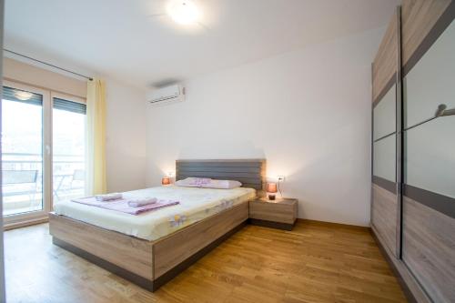 - une chambre avec un lit et une grande fenêtre dans l'établissement Mateja&Fontana Apartment, à Budva