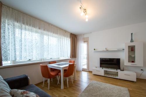 - un salon avec un canapé, une table et une télévision dans l'établissement Mateja&Fontana Apartment, à Budva