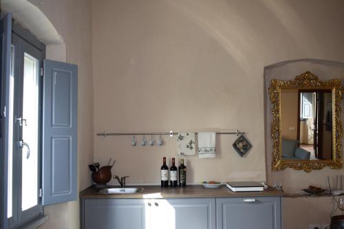 a room with a counter with wine bottles and a mirror at Agriturismo La Posta Reale in Castiglion Fibocchi