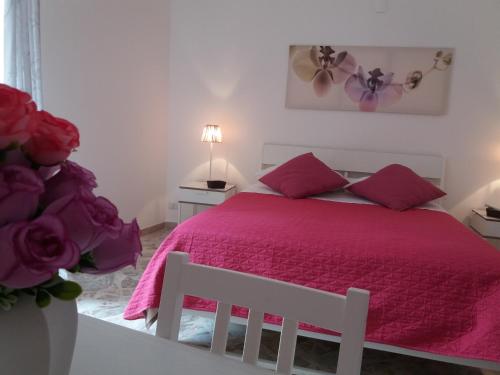 Schlafzimmer mit einem Bett mit rosa Tagesdecke in der Unterkunft Casa Marylisa in Bari