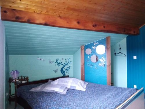 a blue bedroom with a bed with a wooden ceiling at Zimmer mit Frühstück in Challes-les-Eaux