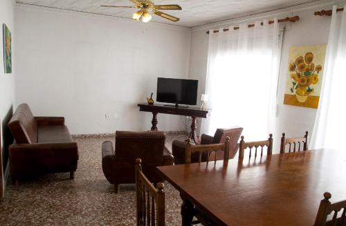 a living room with a dining room table and a television at La Casa 5 de Gandia in Gandía