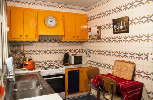 a kitchen with yellow cabinets and a sink and a microwave at La Casa 5 de Gandia in Gandía