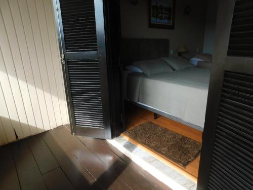 a bedroom with a bed and a door with a rug at Hotel Real São Lourenço in São Lourenço