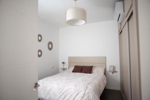 a bedroom with a bed in a white room at Apartamento El Tanguillo Little Apartments in Cádiz