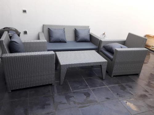 a patio with two wicker chairs and a table at Appartement Agadir Awrir in Agadir