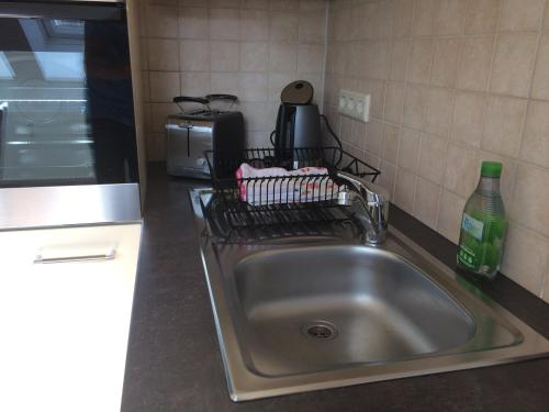 eine Küchentheke mit einer Spüle und einer Mikrowelle in der Unterkunft Ferienwohnung zum Storchennest in Bad Liebenwerda