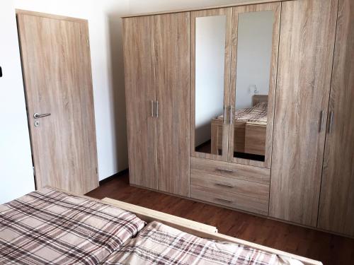 sypialnia z łóżkiem i drewnianą szafką w obiekcie Apartman Erika Lipno w mieście Frymburk