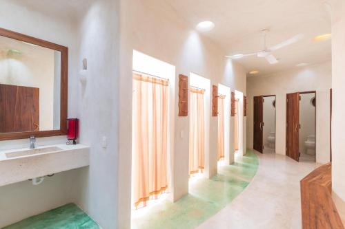 a bathroom with a sink and a row of mirrors at Hotel Holistika Tulum in Tulum