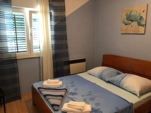 a bedroom with a bed with towels on it at Apartment Ruža in Betina