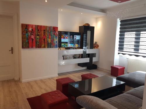 un salon avec un canapé et une télévision sur un mur dans l'établissement le wineck, à Colmar