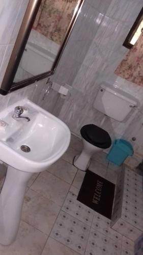 a bathroom with a sink and a toilet at Gya-son Royal Guest House in Kumasi