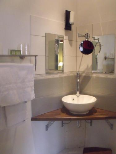 une salle de bain avec un lavabo et un miroir dans l'établissement Relais Saint Louis, Logis, à Bellême