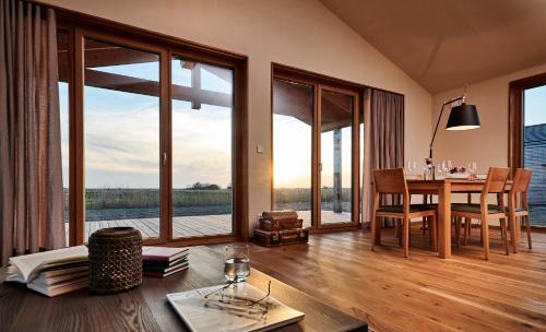 a living room with a dining room table with a view at Gud Jard Lodge Nr 27 - Design-Ferienhaus mit exklusiver Ausstattung in Pellworm