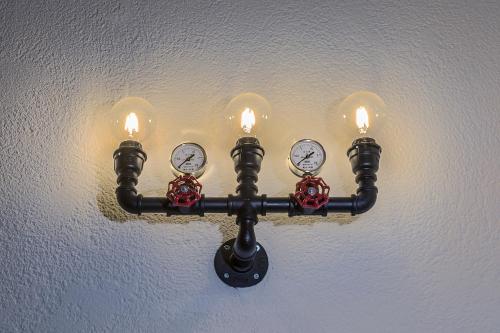a light on a wall with two clocks on it at Cagliari Marina Harbour Guest house & Lounge in Cagliari