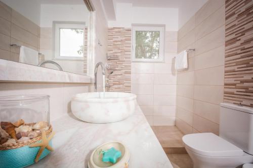 uma casa de banho com um lavatório e um WC em Seaside Apartments em Kaloí Liménes
