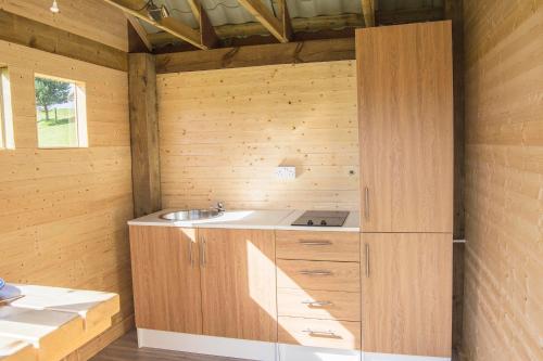 una cucina con lavandino in una parete di legno di Little Lochan Lodge a Glenfarg