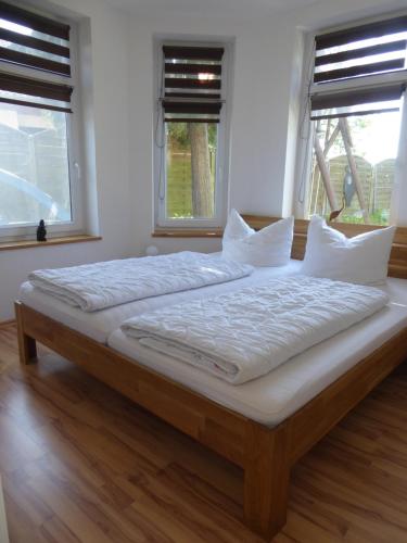 un grande letto in una stanza con due finestre di Ferienhaus Piratenburg Rövershagen a Rövershagen