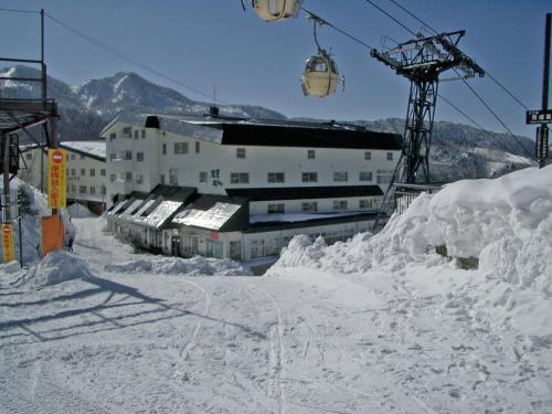 Hotel Iwasuge في يامانوتشي: منتجع التزلج مع كومة من الثلج ومصعد التزلج