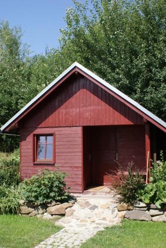 a red barn with a door and a window at Guest House K74 in Jablonné v Podještědí