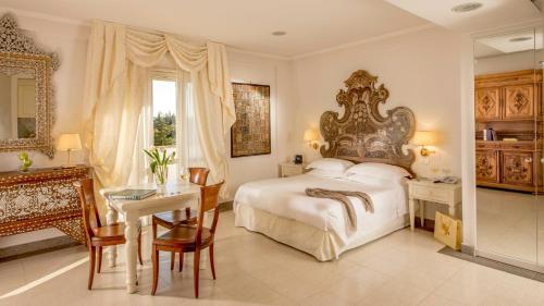 a bedroom with a bed and a table and a desk at Arcom Palace in Pomezia