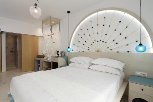 1 dormitorio con cama blanca y cabecero grande en Mylos Luxury Escape en Faliraki