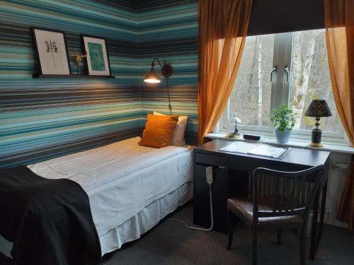 a bedroom with a bed with a desk and a window at Landvetter BnB in Härryda