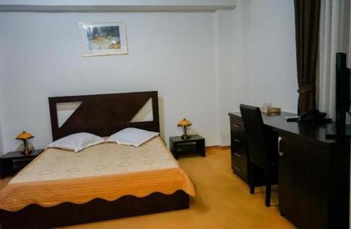 a bedroom with a large bed and a dresser at Hotel Sorelo in Piteşti