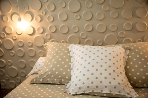 a bed with polka dot pillows in a bedroom at Slope House in Lagoa