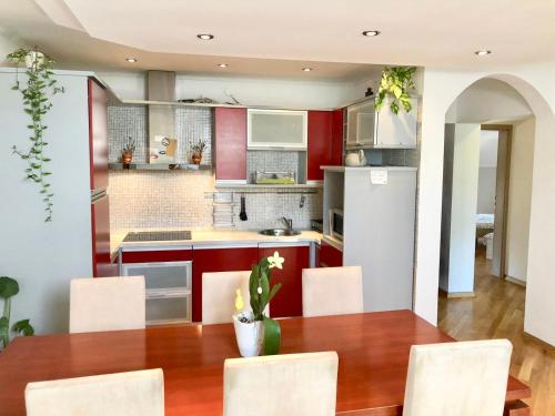 a kitchen with a wooden table and white chairs at Apartments Corina in Zagreb