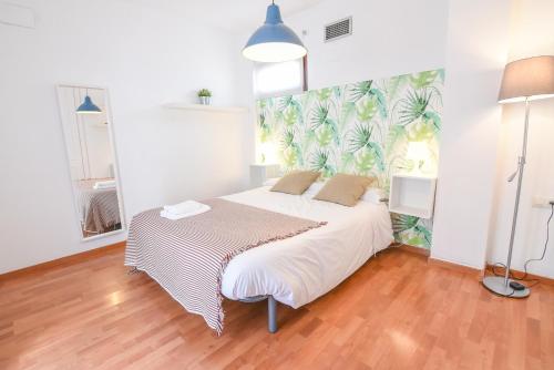 グラナダにあるtuGuest Realejo Apartmentのベッドルーム1室(トロピカルな壁紙のベッド1台付)